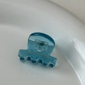 Macro scatto di una mini pinza per capelli blu trasparente con logo Amy Bear dorato - Blu