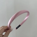 Detalle de diadema de satén rosa claro hecha a mano con etiqueta de fabricación - Rosa