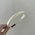 Detalle de una diadema de satén blanco crema con etiqueta hecha a mano en el interior - Beige