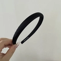 Detalle de diadema de satén negro acolchado con etiqueta de hecho a mano - Negro