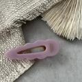 Detail of pink acetate wave hair clip with gold metal clasp and handmade logo lettering - Purple