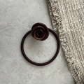 Detailed shot of dark brown rose-shaped hair tie with glossy finish and elastic fabric band - Brown
