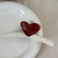 Detail view of cream hair claw clip with a glossy deep red heart on a ceramic plate - Heart-shaped Color Scheme - White