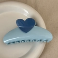 Close-up of blue heart hair claw clip on white ceramic plate with beige fabric - Heart-shaped Color-blocked Fan - Blue