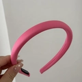 Detail van een felroze gewatteerde haarband van satijn met handgemaakt label erop - Smalle Roze Hoofdband