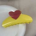 Detail view of yellow shark hair claw clip with a red heart decoration on a ceramic plate - Heart-shaped Color-blocked Fan - Yellow
