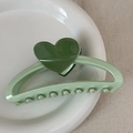 Detail of light green claw clip with dark green hearts on a white ceramic tray - Heart-shaped Color-blocked Clothes Hanger - Green