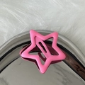 Detail shot of a matte pink star-shaped metal hair clip on a soft white faux fur surface - Deep Pink