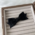 Detail einer schwarzen Satin-Haarspange mit Doppelschleife in einer Holz-Schmuckschatulle - Schwarz