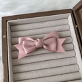 Nahaufnahme der rosa geschichteten Haarschleife mit Seidentextur in einer Samtbox - Rosa