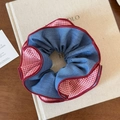 Détail du chouchou en denim bleu et tissu à carreaux rouges aux bords ondulés - Carreaux Rouges