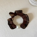 Dettaglio dell'elastico per capelli a quadri marrone con un'elegante grande perla bianca - Caffè Quadri
