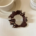 Détail d'un chouchou soyeux café avec bordure léopard sur un fond de tissu minimaliste - Café Avec Bordure Léopard