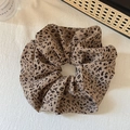 Detailed view of large leopard print scrunchie with vintage fabric texture on white cloth - Light Coffee Leopard