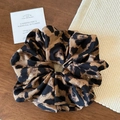 Dettaglio dell'elastico scrunchie con stampa leopardata, texture in seta e stile classico - Leopardo Caffè