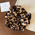 Dettaglio di elastico per capelli maculato con pieghe morbide su base in legno - Leopardo Giallo