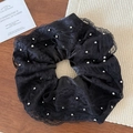 Dettaglio di elastico in raso nero con pizzo e perline argentate su tavolo in legno - Nero