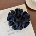 Detailopname van een donkerblauwe geruite stoffen scrunchie met zachte katoenstructuur - Marineblauw