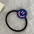 Elastic black hair tie featuring a dark blue round charm with a pink smiley face icon - Blue