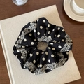Polka dot black fabric scrunchie with lace edge and elastic hair tie on a book - Black Polka Dot Scrunchie