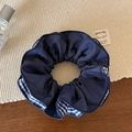 Detailaufnahme von dunkelblauem Satin-Haargummi mit blau-weißem Karomuster-Besatz - Doppellagiger Stil
