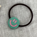 Élastique à cheveux noir avec pendentif vert orné d'un visage souriant rose - Vert