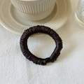 Detalle de un coletero plisado marrón oscuro con una elegante hebilla de resina negra - Café Oscuro