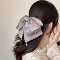 Vue détaillée du nœud en satin lavande avec perles élégantes porté par un modèle - Violet