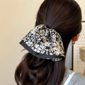 Elegante fermaglio per capelli a fiori con logo dorato su una coda di cavallo - Clip per Coda di Cavallo a Bordo Gonna