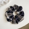 Detailed close-up of a black plaid flannel scrunchie with soft woven fabric texture - Black Hair Tie