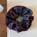 Detailed close-up of blue plaid scrunchie with red trim on a minimalist book background - Navy Blue Plaid