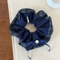 Dettaglio dell'elastico scozzese blu con fiocco in nastro di seta e perla centrale - Blu navy