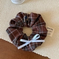 Detalle de coletero vintage de cuadros marrones con lazo de cinta blanca y botones - Café Cuadros