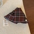 Detalle de la pinza de pelo de tela con cuadros marrones y pequeña placa de metal - Café Cuadros
