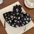 Elegante elastico per capelli con fiocco floreale nero e perla su tavolo in legno - Stile Floreale Nero Perla