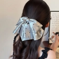 Silberner Satin-Haarclip mit schwarzen Punkten und Perlen an lockigem Haar - Silbergrau Punktemuster