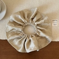 Détail de la texture d'un chouchou en satin champagne avec motif rose jacquard - Champagne