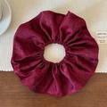 Détail du grand chouchou en satin rouge foncé avec motif floral de roses en relief - Rouge