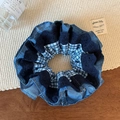 Détail d'un chouchou en denim bleu et dentelle à carreaux sur un fond en bois rustique - Imprimé à Motif Bleu Marine