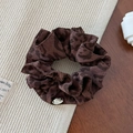 Detailansicht eines Scrunchie mit Leopardenmuster und goldenem Metallanhänger - Braunes Haargummi mit Leopardenmuster