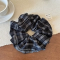 Detail of a vintage black and white plaid fabric scrunchie on a cozy wooden table set - Black Plaid Scrunchie