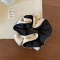 Detailed view of black and white two-tone oversized scrunchie on a rustic wooden background - Beige and Black