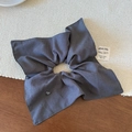 Dettaglio di scrunchie in tessuto a righe grigie con ciondolo a cuore e etichetta - Righe Grigie