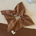 Detail view of handmade caramel velvet hair scrunchie with buttons and hand made label - Brown
