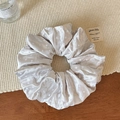 Détail du chouchou en satin gris à pois blancs sur un tapis en paille naturelle - Blanc Cassé