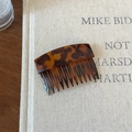 Détail d'un peigne à cheveux à motif écaille de tortue au design vintage sur un livre - Ambre Foncé