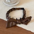 Detailed view of dark brown satin bow headband featuring anti-slip inner grip teeth - Brown