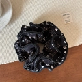 Detalle de coletero de gasa negra con flores que muestra costuras finas y textura de tela - Coletero de Cuatro Capas