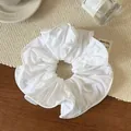 Primer plano de coletero de tela blanca con volantes sobre textura trenzada - Blanco