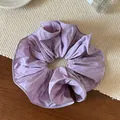 Detalle de un coletero de tela violeta claro con textura plisada en capas y bordes limpios - Morado